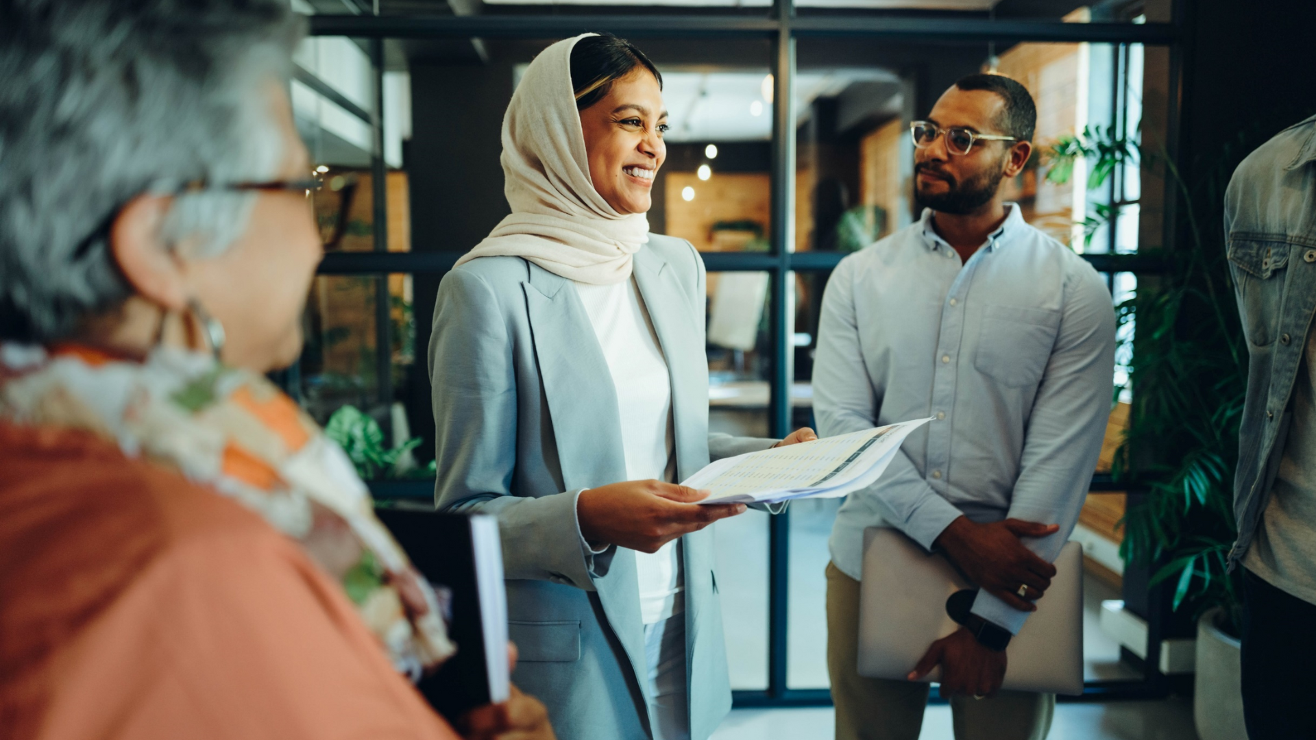 Diverse team of professionals reviewing documents in a modern office—representing collaboration, leadership, and effective programme delivery in the public sector