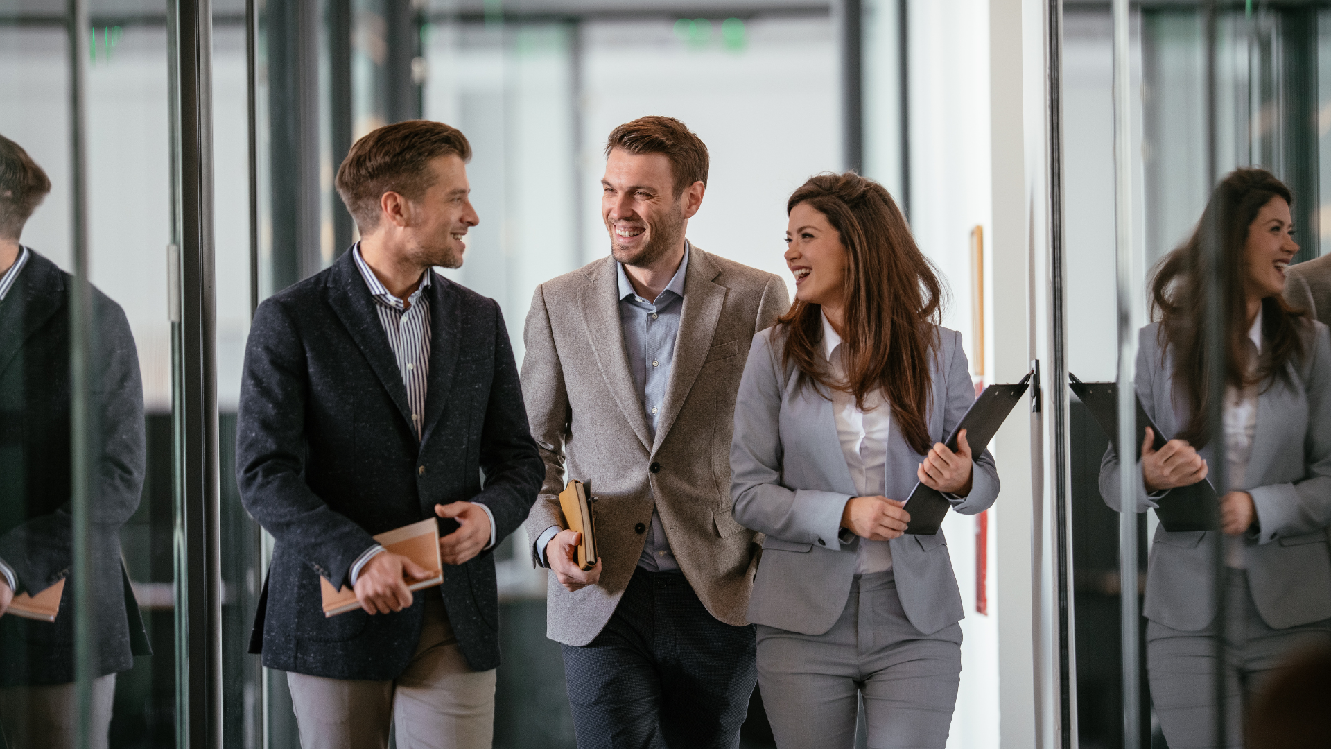 Professional team walking through an office discussing project documents—representing collaboration, governance, and assurance in risk-managed delivery environments